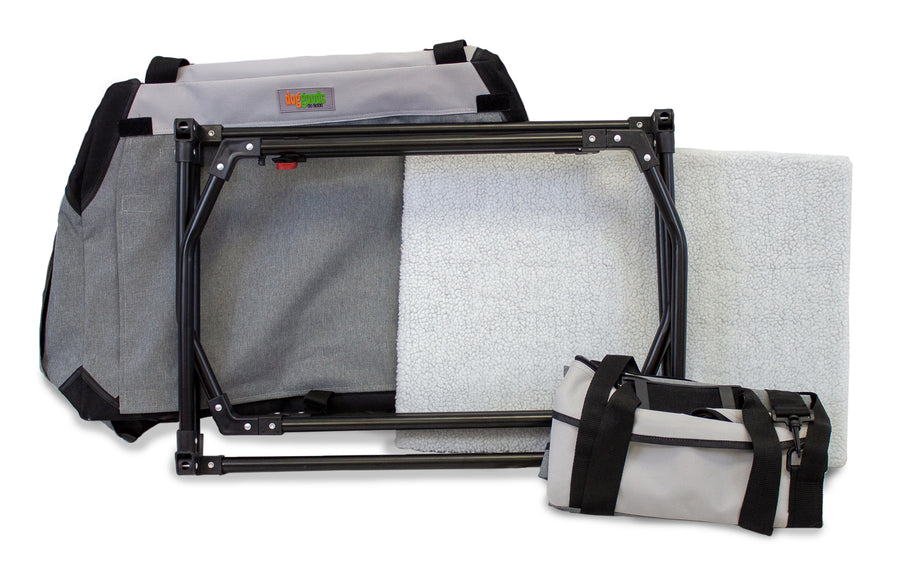 Disassembled DogGoods foldable crate with a sturdy metal frame, soft fleece mat, and compact carrying case for easy transport and storage.