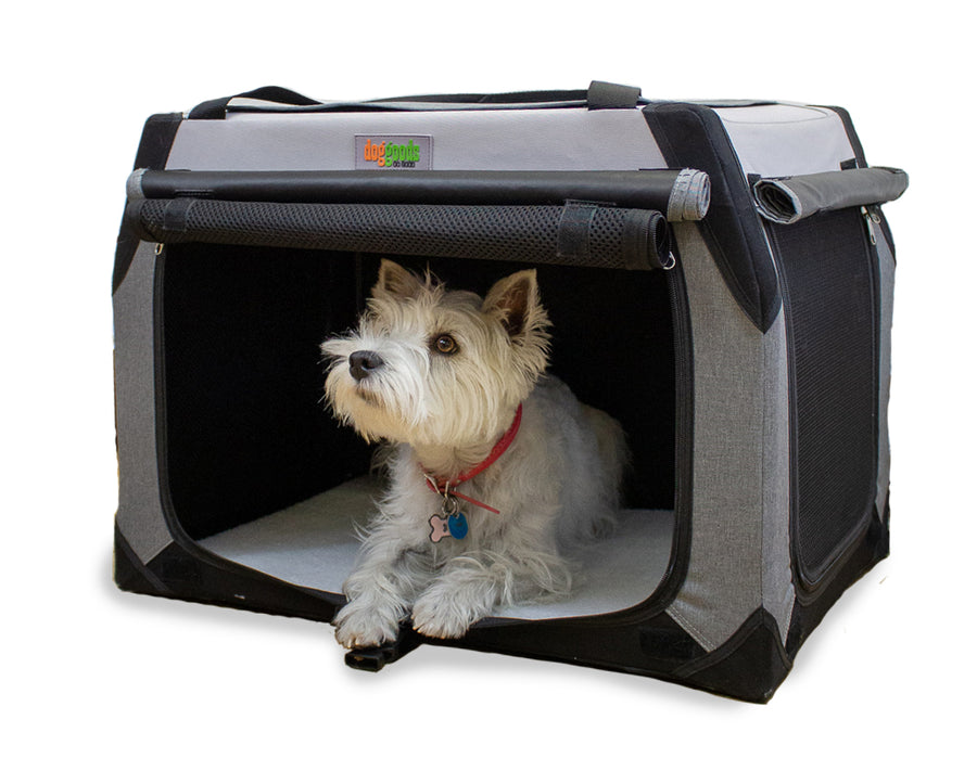 Small white dog resting inside a DogGoods foldable crate with roll-up mesh screens for ventilation and a soft fleece mat for comfort.